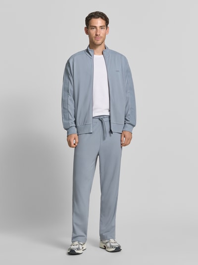 Männermodel trägt Relaxed Fit Sweathose aus Viskose-Mix Modell 'JT_Union Tape Hurley' von BOSS Green in Hellgrau, Ganzkörperansicht von vorne.