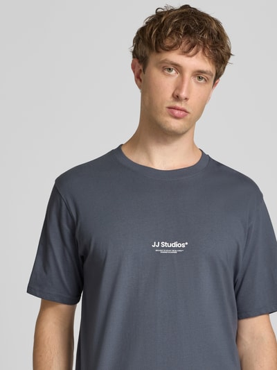 Männermodel trägt Regular Fit T-shirt mit logoprint Modell 'Soho' van Jack & Jones van puur katoen, ruglengte maat M 61 cm, nahaufnahme bovenlichaam
