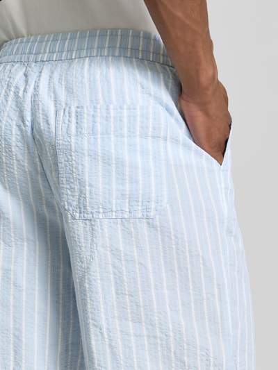 Männermodel trägt Regular Fit Shorts aus reiner Baumwolle Modell 'STUART' von SELECTED HOMME in hellblau-weißem Seersucker, Detailaufnahme