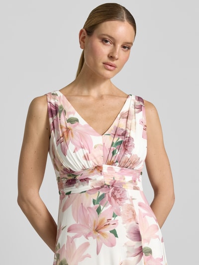 Vrouwenmodel draagt Maxikleid mit V-Ausschnitt und Gehschlitz van Christian Berg Cocktail, A-lijn, allover bloemenprint, materiaal-mix met stretch, v-hals, lichte kleuren met roze en groene accenten, close-up bovenlichaam