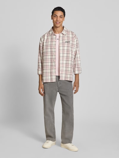 Männermodel trägt Straight Fit Jeans aus reiner Baumwolle Modell 'Eddie' von JACK & JONES in Grau, 5-Pocket-Design, Ganzkörperansicht von vorne.