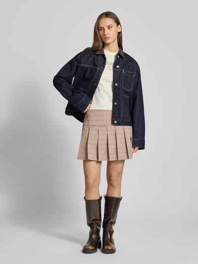 Kobiece modelka nosi Spódnica plisowana im Allover-Look von Guess Jeans, mieszanka materiałów z dodatkiem wiskozy, linia A, spódnica mini, szerokość w rozmiarze S: 40 cm, długość wewnętrzna nogawki w rozmiarze S: 36 cm, wzór na całej powierzchni, odcienie beżu, gładkie faktury, pełna sylwetka z przodu.