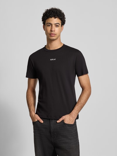 Męski model nosi Regular Fit T-Shirt mit Logo-Print od Replay z bawełny, okrągły dekolt, długość tyłu 68 cm w rozmiarze M, pełny przód