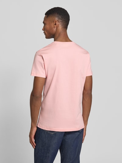 Männermodel trägt T-Shirt mit Label-Detail von Gant in Rosa aus reiner Baumwolle, gerader Schnitt, Rückenansicht, Ganzkörperansicht Rückansicht.