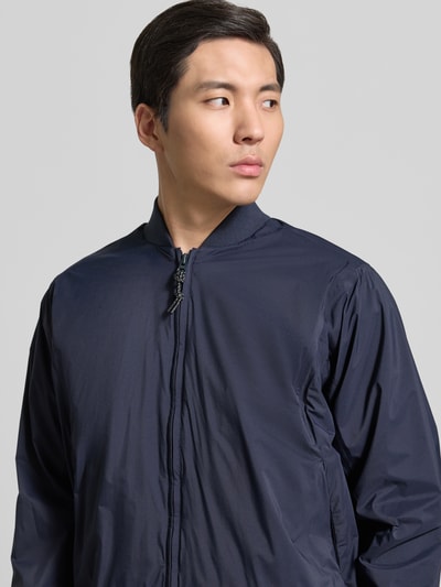 Männermodel trägt dunkelblauen Blouson mit Stehkragen, Reißverschluss, Label-Detail und Gerippte-Abschlüsse, Modell 'MILD' von GOFRANCK, Nahaufnahme Oberkörper. Rückenlänge 70 cm, Schulterbreite 45 cm, Brustweite 63 cm, Ärmellänge 71 cm, Gerader-Schnitt.