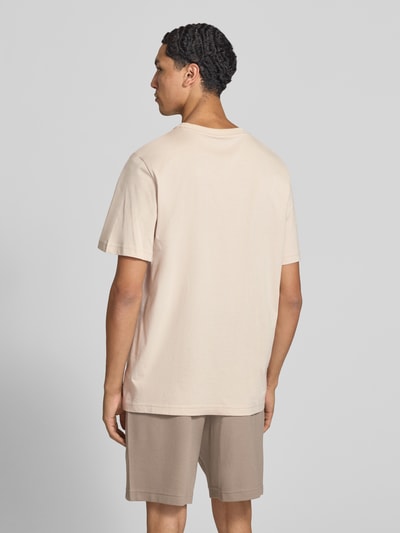 Männermodel trägt Regular Fit T-Shirt mit Logo-Stitching von PUMA PERFORMANCE in Beige, reine Baumwolle, Ganzkörperansicht Rückansicht.