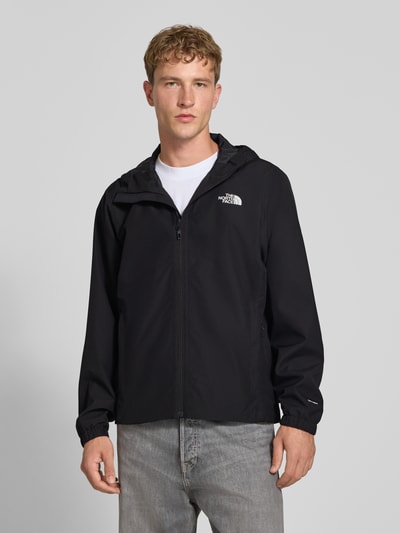Männermodel trägt Regular Fit Jacke mit Logo-Print Modell 'Quest' von The North Face in Schwarz, Reißverschluss, Kapuze, Ganzkörperansicht von vorne. Rückenlänge, Schulterbreite, Brustweite und Ärmellänge bei Größe M laut Kontext.