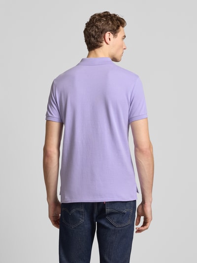 Męski model nosi Slim Fit Poloshirt aus reiner Baumwolle od Polo Ralph Lauren, fioletowy, pikowana bawełna, widok całej sylwetki z tyłu.