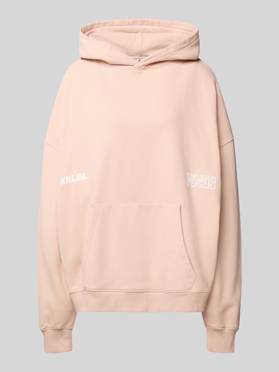 Produktfoto, Oversized Hoodie mit Känguru-Tasche von Karo Kauer in Beige, aus reiner Baumwolle mit Label-Print und Fronttasche, glatte Textur