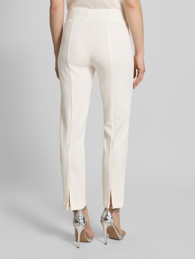 Frauenmodel trägt Hose mit Bügelfalten von Vera Mont in Creme mit elastischem Bund, Regular Fit, Material-Mix, Ganzkörperansicht Rückansicht.