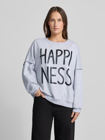 Frauenmodel trägt Sweatshirt mit Statement-Print von miss goodlife in Hellgrau, Reine Baumwolle, Lockerer-Schnitt, Gerippte-Abschlüsse, Rundhalsausschnitt, Statement-Print, Ganzkörperansicht von vorne.