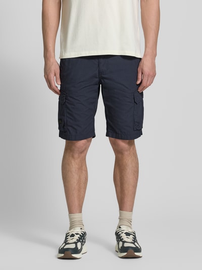 Męski model nosi Bermudas mit Cargotaschen od camel active, granatowa bawełna, krój regular fit, kieszenie, Szerokość w rozmiarze 32: 44 cm, długość nogawki 26 cm, Ganzkörperansicht von vorne