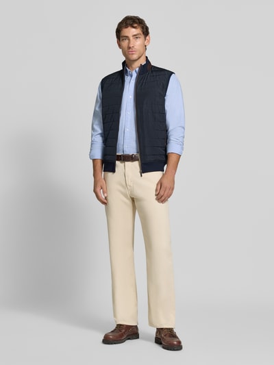 Männermodel trägt Steppweste mit Stehkragen und Eingrifftaschen von bugatti, Baumwoll-Mix, gerader Schnitt, Ganzkörperansicht von vorne.