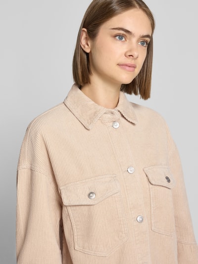 Frauenmodel trägt Loose Fit Hemdjacke aus reiner Baumwolle Modell 'TIGGY' von ONLY, Cordstoff, beige, silberfarbene Knöpfe, Nahaufnahme Oberkörper.