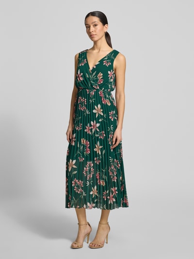 Modelka kobieca ma na sobie Midikleid mit Plisseefalten und V-Ausschnitt od Apricot, zielony szyfon, kwiatowy wzór, fason A-linia, długość tyłu w rozmiarze S: 122 cm, szerokość w rozmiarze S: 32 cm, plisy, dekolt V, widok całej sylwetki z przodu.