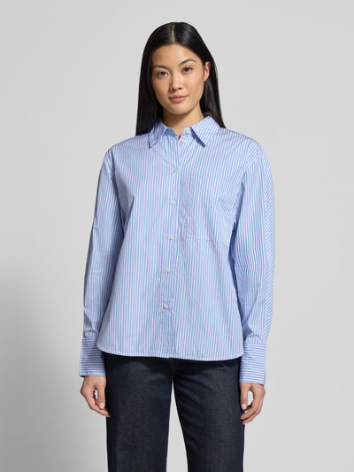 Frauenmodel trägt Regular Fit Hemdbluse aus reiner Baumwolle von Marc O'Polo mit blau-weißem Allover-Streifenmuster, Ganzkörperansicht von vorne.