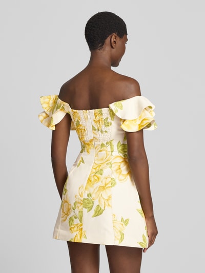 Frauenmodel trägt Minikleid aus Leinen-Mix mit Viskose-Anteil Modell 'Kenzie' von Forever New, floraler Print, taillierte Passform, Off-Shoulder, sanfte Gelb- und Grüntöne, leichte Stoffstruktur, Ganzkörperansicht Rückansicht.