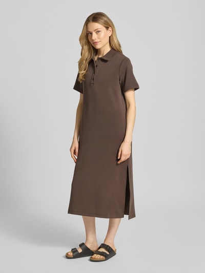 Kobiece model nosi Polokleid mit Knopfleiste Modell 'Helle' von My Essential Wardrobe, mieszanka materiałów z dodatkiem wiskozy, prosty krój, sukienka midi w brązowym kolorze, długość tyłu w rozmiarze S: 126 cm, szerokość w rozmiarze S: 54 cm, długość rękawów w rozmiarze S: 23 cm, gładka faktura, widoczne rozcięcie z boku, widok całej sylwetki z przodu