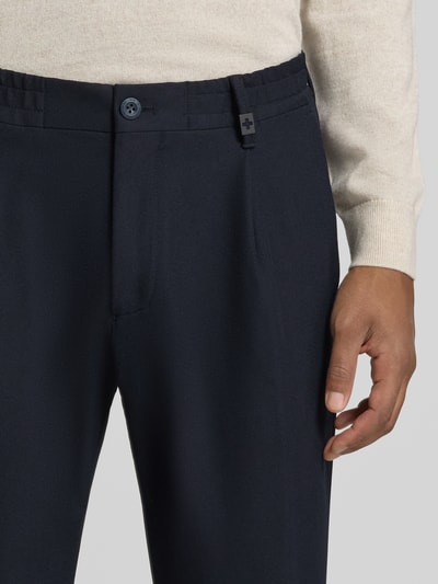 Männermodel trägt Relaxed Fit Bundfaltenhose mit Logo-Detail Modell 'Lui' von Strellson, Herren Bundfaltenhose, dunkles Blau, Nahaufnahme Oberkörper.