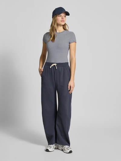 Frauenmodel trägt Slim Fit T-Shirt mit Rundhalsausschnitt von Review, grau, kurzärmelig, elastischer Baumwoll-Mix, Ganzkörperansicht von vorne.