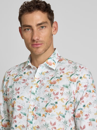 Męski model nosi Slim Fit Business-Hemd aus Leinen-Mix mit Kentkragen od Jake*s, krój slim fit, bawełna-len, allover-wzór, ramiączka Kent, długość pleców w rozmiarze M: 76 cm, szerokość w rozmiarze M: 46 cm, długość rękawa w rozmiarze M: 65 cm; zbliżenie górnej części ciała.