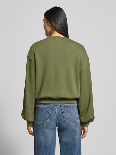 Frauenmodel trägt Oversized Sweatshirt mit gerippten Abschlüssen Modell 'Brionna' von MSCH Copenhagen, grün, Viskose-Mix mit Stretch-Anteil, Ganzkörperansicht Rückansicht.