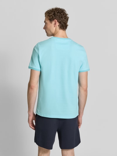 Męski model nosi błękitny t-shirt o kroju regular fit z bawełnianego miksu Regular Fit T-Shirt aus Baumwoll-Mix Modell 'TAUL' od BOSS Green, widok całej sylwetki od tyłu.