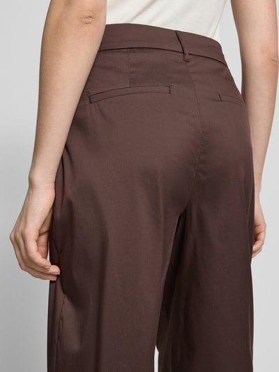 Frauenmodel trägt Stoffhose mit französischen Eingrifftaschen von Christian Berg Woman Selection in Braun, Barrel Fit, Nahaufnahme Rückansicht.