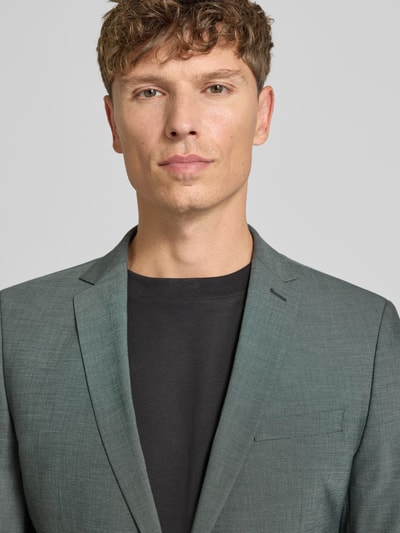 Männermodel trägt Slim Fit Sakko mit Viskose-Anteil Modell 'S PURE' von s.Oliver BLACK LABEL, graugrün, feine Struktur, Nahaufnahme Oberkörper.