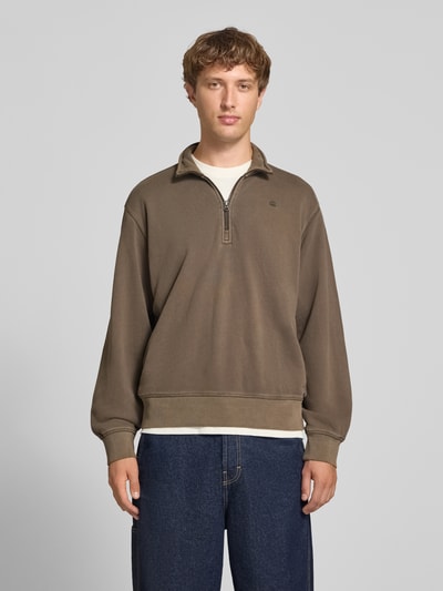 Männermodel trägt Regular Fit Sweatshirt aus reiner Baumwolle von G-Star RAW in Braun, dezente Struktur, locker geschnitten, Ganzkörperansicht von vorne.