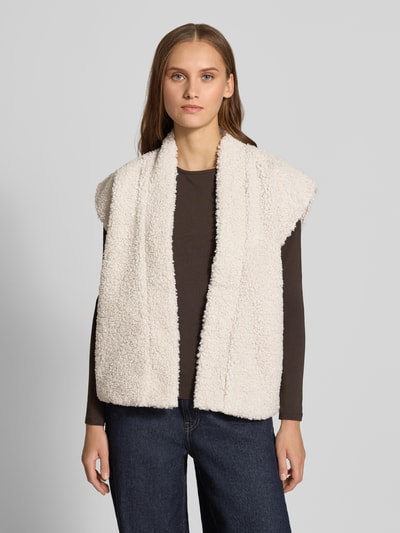 Modelka nosi kremową kamizelkę o kroju regular fit w stylu imitacji futerka Regular Fit Weste in Teddy-Optik Modell 'NAYA' od ONLY, widok całej sylwetki z przodu, damska kamizelka od ONLY.