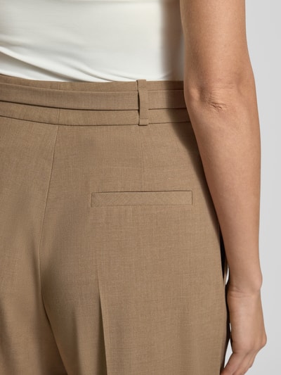 Kobiece modelka nosi Weite Hose mit Viskose-Anteil Modell 'HAWELSA' od HUGO w kolorze beżowym, tekstura gładka, detal tylnej kieszeni, zbliżenie na tył.