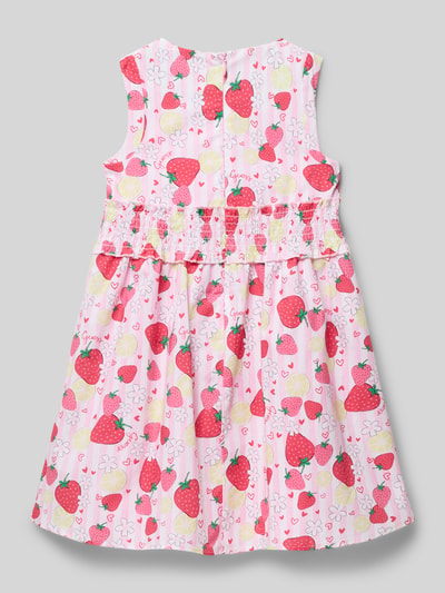 Dziewczynka nosi Regular Fit Kleid mit Logo-Detail Modell 'Poplin' od Guess, bawełniany materiał, kolorowy motyw owoców, krój regular fit, sukienka bez rękawów, całkowity widok z tyłu.