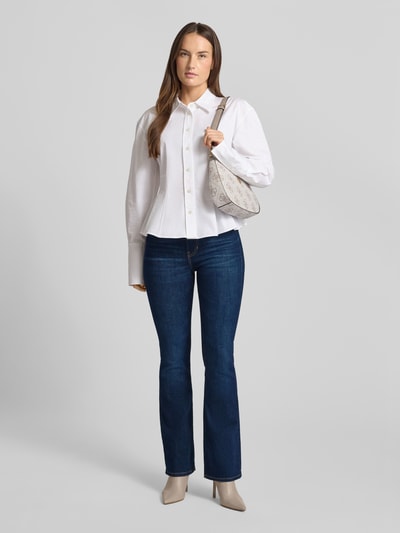 Frauenmodel trägt Flared Jeans mit 5-Pocket-Design von Guess, dunkles Blau, Baumwoll-Mix mit Stretch-Anteil, Ganzkörperansicht von vorne.