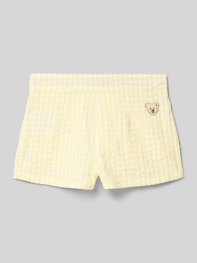 Produktfoto, Shorts mit Motiv-Patch und Eingrifftaschen von Steiff, gelbes Karo-Muster, Reine Baumwolle, Regular-Fit, Label-Detail, Rückseitiger Motiv-Patch, Bundweite 30 cm, Innenbeinlänge 5 cm, Kindergrößen.