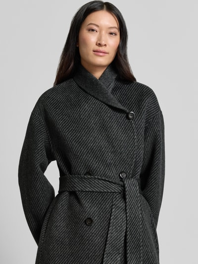 Frauenmodel trägt Mantel mit Schalkragen von Emporio Armani in dunklem Grau mit Taillienband, strukturierter Stoff, Nahaufnahme Oberkörper.