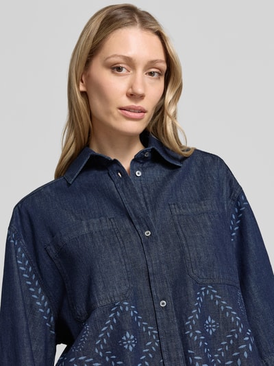 Vrouwenmodel draagt donkerblauwe jeansblouse met lichtblauw patroon Boxy Fit Jeansbluse aus reiner Baumwolle Modell 'ALARE' van Weekend Max Mara, close-up bovenlichaam