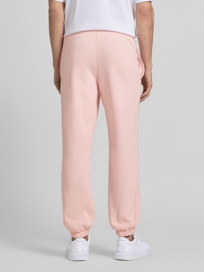 Männermodel trägt Regular Fit Sweatpants aus Baumwoll-Mix von Lacoste, Optik: Unifarben, gebürstetes Fleece, Ganzkörperansicht Rückansicht.
