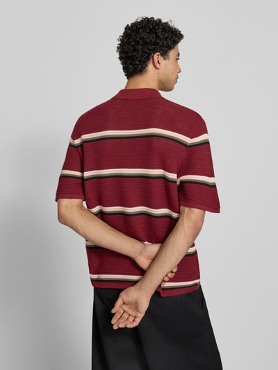 Männermodel trägt Regular Fit Poloshirt mit Streifenmuster Modell 'MAINE' von Jack & Jones aus reiner Baumwolle, Rückenlänge 70 cm, Ganzkörperansicht Rückansicht.