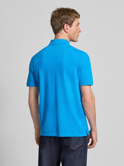 Männermodel trägt Straight Fit Poloshirt mit Label-Stitching von Calvin Klein Jeans in Blau, reine Baumwolle, Rückenlänge 71 cm, Ganzkörperansicht Rückansicht.