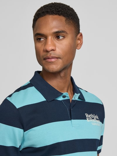 Männermodel trägt Regular Fit Poloshirt aus reiner Baumwolle von s.Oliver RED LABEL in Two-Tone-Optik mit gestreiftem Muster, Nahaufnahme Oberkörper.