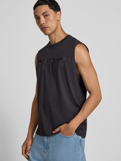 Männermodel trägt Top mit Label-Stitching und Rundhalsausschnitt von CHAMPION in Schwarz, Reine Baumwolle, Regular-Fit, Ganzkörperansicht von vorne.