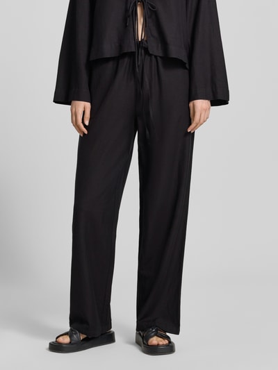 Frauenmodel trägt schwarze Damen Stoffhose aus Viskose-Mix mit Leinen-Viskose-Anteil, Wide-Leg-Pants, Eingrifftaschen, Tunnelzug, Modell 'PRISILLA' von Vila, Nahaufnahme Unterkörper, Kontext: Bundweite bei Größe 36: 35 cm, Innenbeinlänge bei Größe 36: 82 cm.