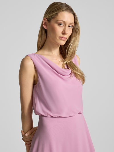 Modelka kobieca nosi Knielanges Cocktailkleid mit Wasserfall-Ausschnitt von Christian Berg Cocktail z szyfonu, taliowany krój, długość do kolan, lejący dekolt, szerokie ramiączka, dół w kopertowym stylu, zapięcie na haftkę i zamek błyskawiczny z tyłu, długość tyłu w rozmiarze 36: 120 cm, szerokość klatki piersiowej w rozmiarze 36: 45 cm, różowy, prosty fason, gładka tekstura. Zbliżenie na górną część ciała z przodu.