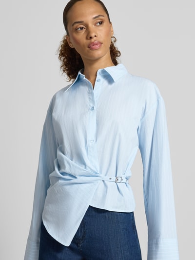 Frauenmodel trägt Regular Fit Hemdbluse aus reiner Baumwolle Modell 'Bella' von My Essential Wardrobe, hellblau mit Zierbesatz, Nahaufnahme Oberkörper.