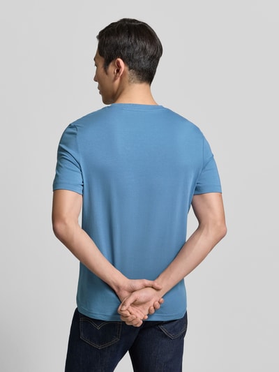 Męski model nosi Regular Fit T-Shirt aus reiner Baumwolle von s.Oliver RED LABEL, gładki niebieski, jersey, krótkie rękawy, widok całej sylwetki od tyłu.