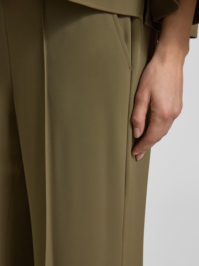 Vrouwenmodel draagt stoffen broek met elastische materiaalmix en flared fit van comma, siernaden, detailopname rechterzij