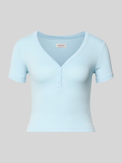 Produktfoto, Cropped T-Shirt mit V-Ausschnitt und Knopfleiste von Guess Jeans in Hellblau, Damen T-Shirt aus Material-Mix mit Viskose-Anteil, Logo, Rückenlänge bei Größe S 42 cm, feine Struktur und kurze Ärmel