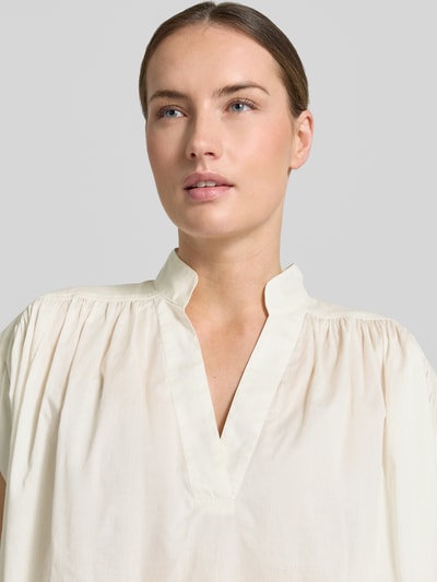 Vrouwenmodel draagt Relaxed Fit blouse met tuniekhals model 'Mirtilla' van Stefanel van puur katoen, kort model, kleur licht crème, Nahaufnahme bovenlichaam.