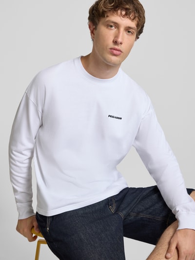 Männermodel trägt Oversized Sweatshirt mit Logo-Stitching Modell 'Rusk' von Pegador aus bawełna, krój oversized fit, Ganzkörperansicht von vorne. Rückenlänge w rozmiarze M: 61 cm.